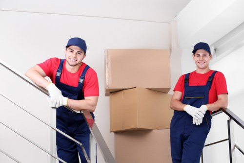 Removal team carrying furniture through a flat hallway
